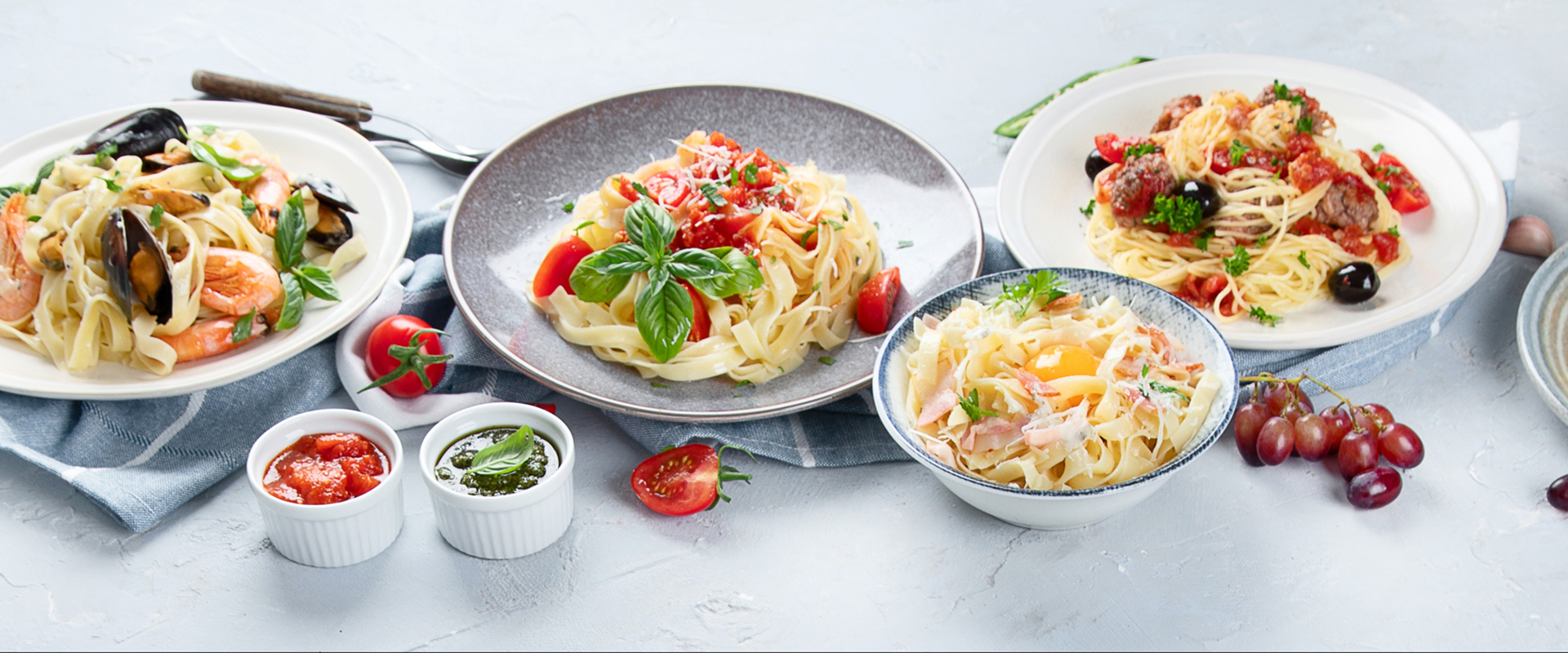 Plates of pasta with various toppings on a table